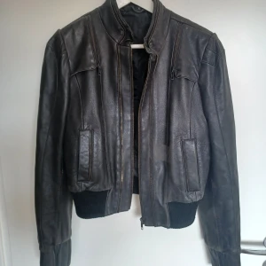 Vintage äkta läderjacka - Vintage läderjacka som köptes i Stor Britanien. Jacka är gjort av äkta läder. Storlek är 10 UK/ 38EU. Jacka är svart.