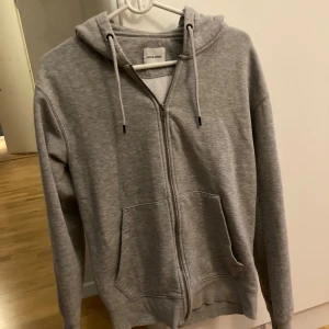 Grå Jack and Jones hoodie - En grå Jack and Jones hoodie. 9,5/10 skick använd endast ett fåtal gånger. Storlek Xs