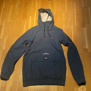 Blå skidjacka från Dope - Säljer en snygg blå skidjacka från Dope med en stor ficka framtill och justerbar huva. Varm och bekväm perfekt i skidbacken. Väldigt bra skick, inga skador. Storlek S, Nypris 1899kr.