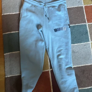 ljusblå mjukisbyxor från Hoodrich - Säljer ett par ljusblåa mjukisbyxor från hoodrich med snörning i midjan och en broderad logga på benet. Perfekta för en avslappnad stil.