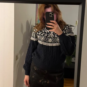 Mönstrad stickad tröja från Holly & Whyte - Säljer en snygg stickad tröja från Holly & Whyte med ett klassiskt mönster i svart och vitt. Tröjan har långa ärmar och en rund halsringning, perfekt för kyliga dagar. Den är både stilren och bekväm.