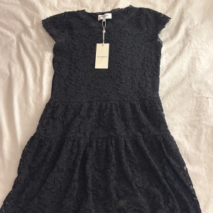 Svart spetsklänning  - Elegant svart spetsklänning från Rosemunde med korta ärmar och ett vackert blommönster. aldrig använd och lappen sitter kvar. nytt skick 