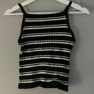 Svart och vit randig ribbad linnetopp - Snygg svart och vit randig linnetopp med ribbad struktur. Perfekt för sommaren. Passar utmärkt till både jeans och kjol. Storlek 146/152 men passar xxs och xs också.