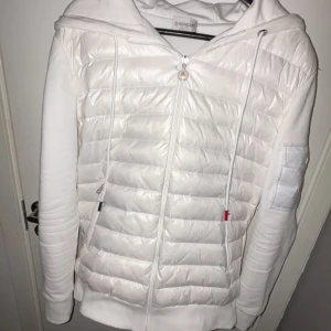 Moncler Cardigan - Tja, säljer en snygg vit cardigan från Moncler med dragkedja och huva. Jackan har långa ärmar och en stilren design med Moncler-logga på ärmen. Perfekt för våren. Priset kan diskuteras vid snabb affär.