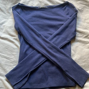 Mörkblå långärmad topp från Gina Tricot - Säljer en stilren mörkblå långärmad topp från Gina Tricot. Toppen har en enkel design med rund hals och är tillverkad i ett mjukt material. Perfekt för en avslappnad look eller att klä upp med accessoarer.