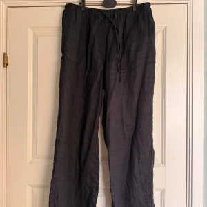 Svarta linnebyxor med snörning - Snygga svarta linnebyxor med avslappnad passform och snörning i midjan. Perfekta för en bekväm och stilren look.