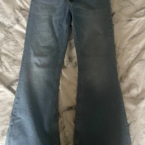 bootcut jeans - Snygga blå bootcut jeans med klassisk femficksdesign. Perfekta för en avslappnad stil. De har en knapp och dragkedja framtill.