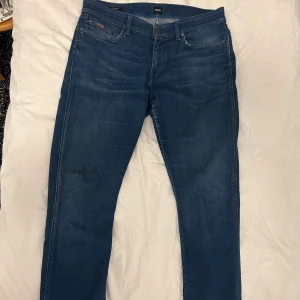 Blå jeans från Boss - Snygga blå jeans från Boss. De har en modern passform som sitter bekvämt längs benen. De har ett stretch sitt material. Storlek är 33-34