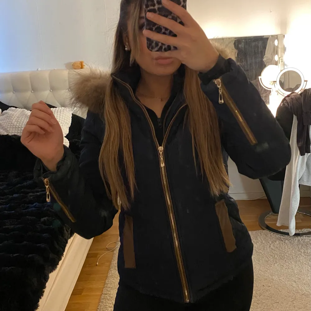 Säljer en snygg marinblå vinterjacka med pälsdetaljer på huvan. Jackan har dragkedja och flera praktiska fickor med dragkedjor. Perfekt för kalla dagar och ger en stilren look. Passar bra till både vardag och utflykter.. Takit.