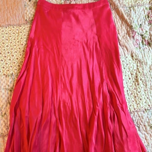Rosa långkjol från Indiska - Säljer en vacker rosa långkjol från Indiska. Superskönt och svalt tyg så perfekt för utekvällar på sommaren. Den har även en slits på framsidan! Faktiskt aldrig använd - längden är ca 76 cm och midjan tvärs över är ca 37 cm. Snälla ignorera skrynklorna på bilden, den är inte menad att vara skrynklig det är bara jag som inte har strykt den än 👍🏻