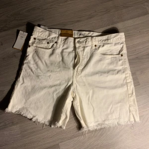 Vita jeansshorts från Polo Ralph Lauren - Snygga vita jeansshorts från Polo Ralph Lauren med råa kanter och knappgylf. Aldrig andvända. Ge gärna prisförslag😁