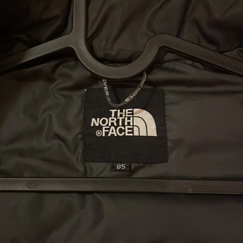 Säljer en snygg och varm röd dunjacka från The North Face. Jackan har svarta detaljer på axlarna och en dragkedja framtill. Perfekt för kalla vinterdagar. Den är i mycket bra skick och har en normal passform. Passar både till vardags och utomhusaktiviteter.. Jackor.