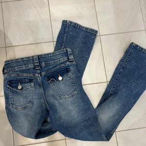 Blå bootcut jeans från H&M - Säljer ett par snygga blå bootcut jeans från H&M i storlek EUR 158. De har låg midja och justerbar midja för perfekt passform. Jeansen är i bra skick och passar perfekt för en avslappnad stil. Perfekta för både vardag och fest! Lågmidjade❤️