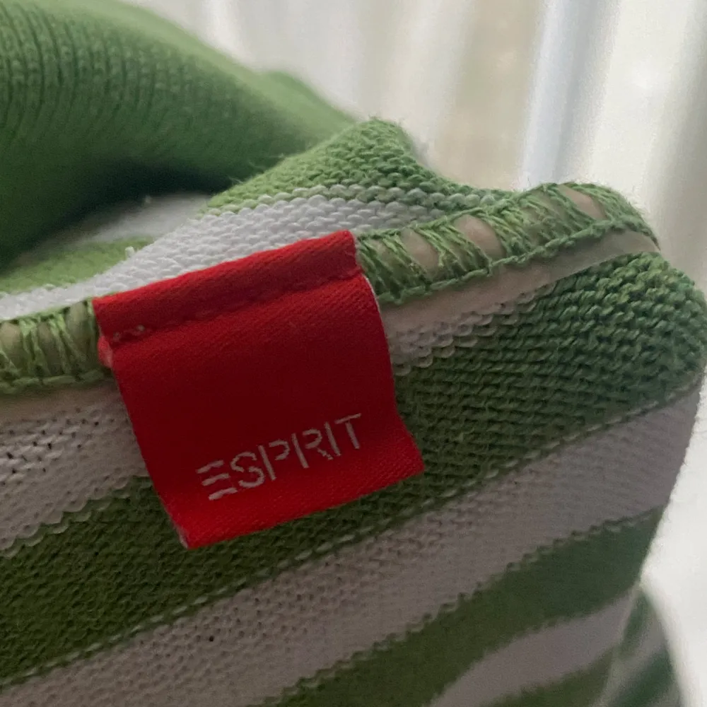 Säljer en superfin grön- och vitrandig topp från Esprit. Den har en v-ringad design med knappar framtill och korta ärmar. . Toppar.