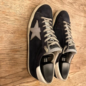 Golden Goose - Golden Goose | Modell - Superstar | Storlek 41.5, passar både 41+42 också | Bra skick, men tecken på använding finns men inga tydliga tecken på slitage | Skick: 8/10 | Färg: Skorna - marinblå, stjärnan - silver, grå / Mvh 