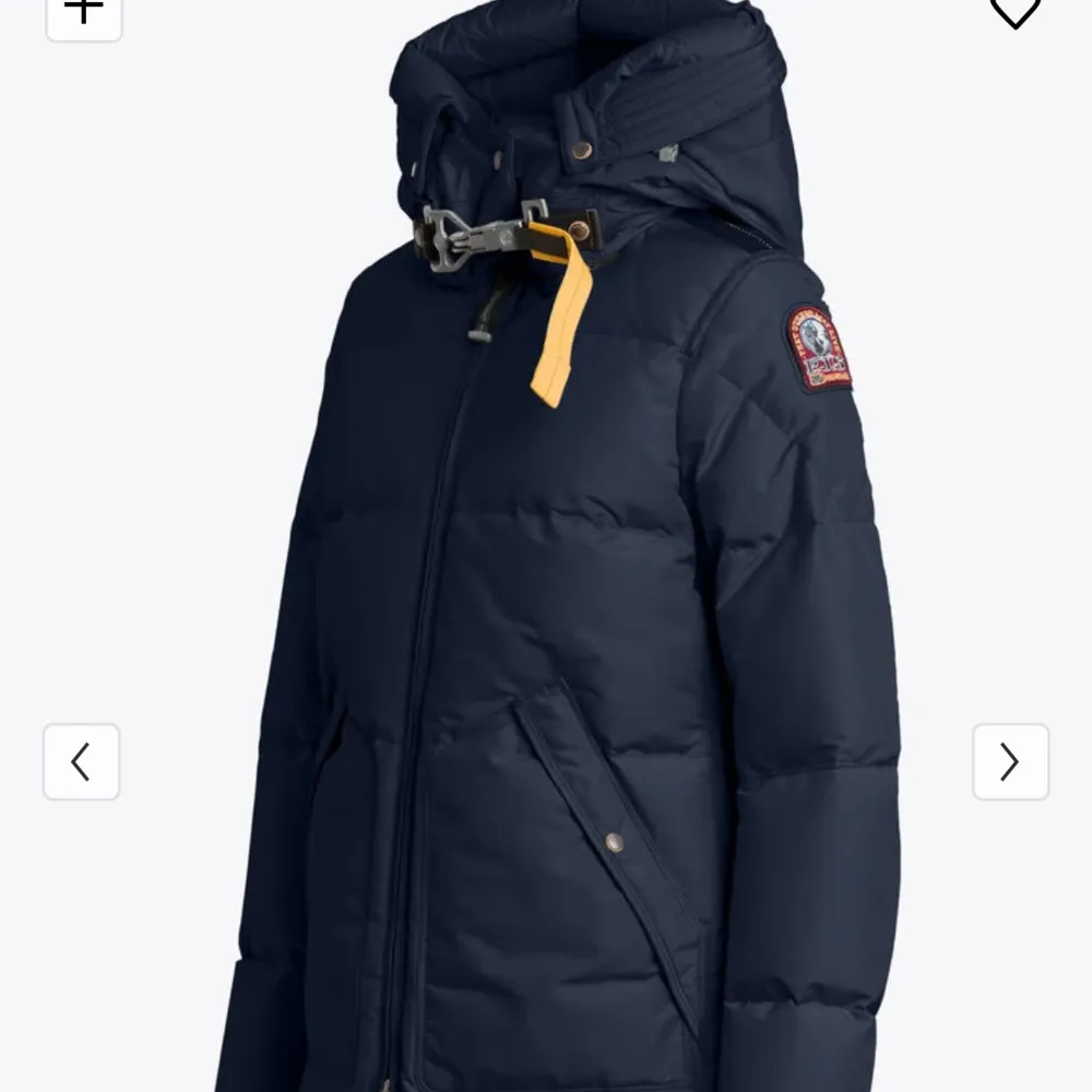 Säljer en snygg och varm mörkblå dunjacka från Parajumpers. Jackan har en praktisk huva och stängs med dragkedja. Den har långa ärmar och en cool detalj med gul rem vid halsen. Perfekt för kalla vinterdagar! 🧥❄️(äkta päls ingår!). Jackor.