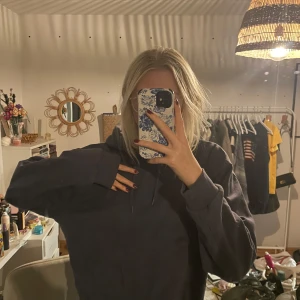 navy blå hoodie - Säljer en mysig mörkblå hoodie i bra skick. Den har en klassisk design med långa ärmar och en stor ficka framtill. Perfekt för höst och vinter när du vill hålla dig varm och bekväm. Passar till det mesta i garderoben!