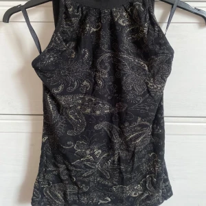Halterneck topp med gulddetaljer - Står storlek 38 passar xs-s😝 Så snygg topp till fest att matcha med jeans eller kjol😍😍 Perfekt till nyår😘😘 Utomlands