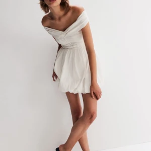 Crèmevit offshoulder klänning - Säljer en superfin vit offshoulder klänning med en kort och luftig design. Perfekt för sommarens fester eller midsommar eller stundenten. Den är köpt från HM, endast testad och prislappen finns kvar. Skriv vid minsta fundering💕