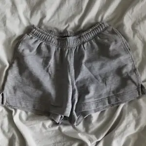 Säljer ett par grå shorts från BikBok i mjukt bomullsmaterial. De har en elastisk midja för extra komfort och en avslappnad passform. Perfekta för en chill dag hemma eller en promenad i parken. 🩶