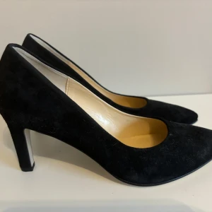 Gabor svarta pumps - Stl 38,5 - Snygga svarta pumps från Gabor i mocka. De är väldigt sparsamt använd så de är i jättefint skick. Klackhöjd är ca 7 cm.  Storlek: 38,5  Nypris: 1300 kr