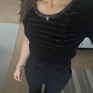 Glittrig stickad topp - Glittrig stickad t-shirt i nyskick! Köpt second hand och finns ingen lapp men passar som s. 