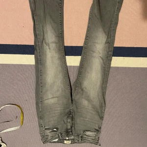 Gråa ONLY jeans - Jättefina jeans från ONLY köpta från Zalando. De är i storlek 34/M.     De har ett litet hål högt upp pågrund av att en krok har rivits av lite. Innerbenslängd: 89cm Midjemått: 37cm