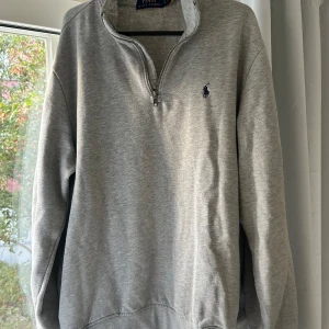 Grå tröja med dragkedja från Ralph Lauren - Säljer en stilren grå tröja från Ralph Lauren. Tröjan är i suveränt skick och superbekväm! Använd fåtal gånger. Ny pris ligger runt 2000kr säljer för 799
