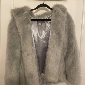 Grå pälsjacka  - Grå pälsjacka. Tjock. Aldrig använd 