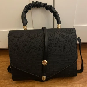 Väska - Jätte fin väska som är helt ny och oanvänd, köpt i Dubai. Går att använda som handväska, men även axelremsväska då det finns ett band som man kan sätta på💕priset går såklart att diskutera om💕