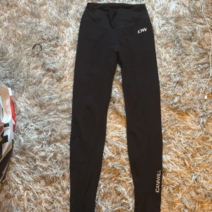 Svarta leggings från ICANIWILL - Säljer ett par svarta leggings från ICANIWILL. De är tighta och perfekta för träning. Materialet är mjukt och stretchigt, vilket gör dem bekväma att bära. De har en hög midja och en snygg rynkdetalj bak som ger en fin passform.