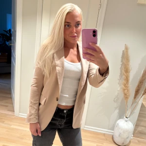 Beige kavaj - Beige kavaj i storlek 32. Känns som en storlek XS/S skulle jag säga. Oanvänd.