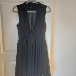 Klänning  - Svart klänning med guldknappar, har bra material och i bra skick