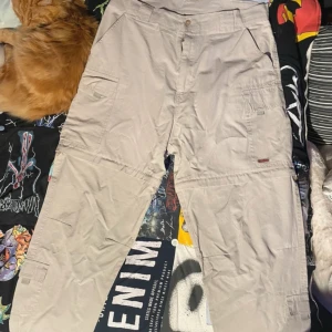 Beiga cargo byxor/shorts  - Cargobyxor som kan bli till shorts, bra kvalitet dem har en fläck från gräs(bild 4) annars bra  Storleken säger XXL men den passar mer L/M