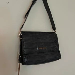 Valentino väska - Säljer denna Valentino väska som är i fint skick förutom några repor på V märket som hänger på sidan! Denna väska säljs ej längre på deras hemsida!