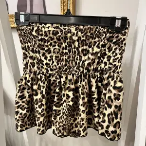 Säljer en supercool leopardmönstrad tubtopp som är perfekt för att sticka ut! Toppen har en smockad midja som ger en bekväm och flexibel passform. Materialet känns mjukt och lätt, vilket gör den idealisk för varmare dagar. Perfekt för en utekväll!