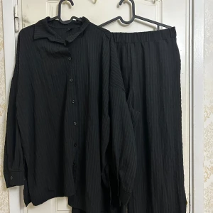 Skjorta och byxor set  - Ett set bestående av en svart skjorta med knappar och matchande byxor. Använts 1 gång. Väldigt trendiga. 