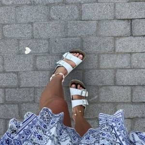 Vita Birkenstock - Säljer mina vita birkenstock med gulddetaljer i bra skick inga tidliga deffekter i storlek 38💕💕🥰 passar 37-39  Nypris - 1100