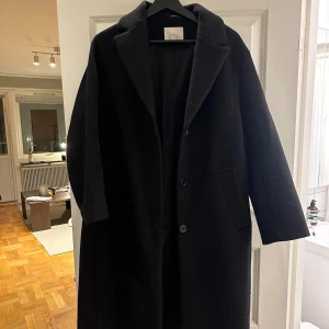 Lång kappa HM - Lång kappa från H&M. Använt sparsamt och i fint skick. Svart. Storlek S
