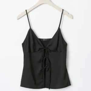 Fin satin topp - Jätte fin svart satintopp med knytningar fram som man kan justera själv hur man vill, den är slutsåld på hemsidan.  Den är oanvänd  med prislapp kvar. Storlek XS Ursprungspris: 359kr