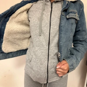 En väldigt enkel blå pälsig jacka  - Ganska kort och är i storlek 36. Kan användas på våren och hösten. Ganska gammal men har inte används många gånger.