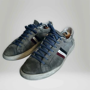 Moncler Monaco Stripe Sneaker - Säljer ett par Ljusblå sneakers från Moncler i mocka. De har en snygg design med blå snörning och Monclers klassiska ränder i rött, vitt och blått på sidan. Box kommer ej med, kan frakta eller mötas upp i Stockholmsområdet!