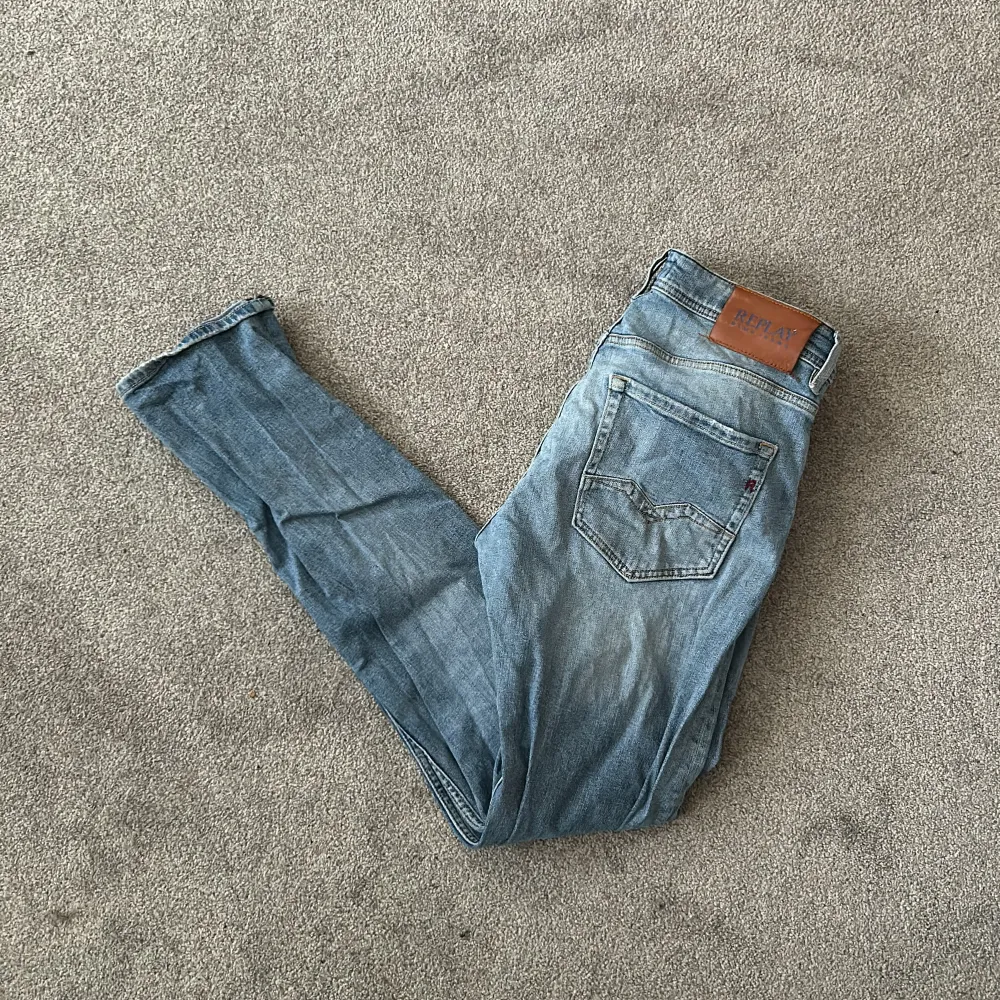 Säljer ett par snygga blå jeans från Replay, modell Rocco. De har en klassisk femficksdesign och en ljus tvätt som ger en avslappnad look. Perfekta för både vardag och fest!. Jeans & Byxor.