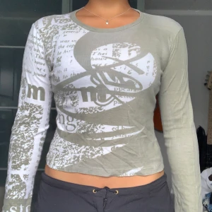 Grön långärmad topp med tryck - Säljer en cool grön långärmad topp med unikt tryck. 