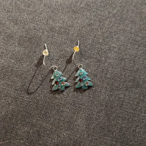 Julgransörhängen med färgglada detaljer - Superfina örhängen i form av små julgranar! De är gröna med röda och gula detaljer som ser ut som julgranskulor. Perfekta för att sprida julstämning på festen eller middagen. De har en enkel krok för att hänga i öronen. Passar perfekt till julens alla festligheter! 🎄✨