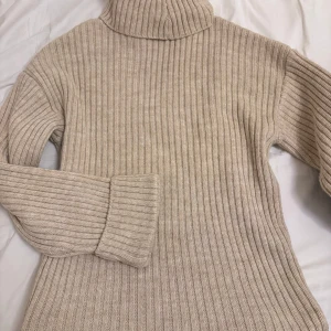 Beige ribbad polotröja - Säljer en supermysig beige polotröja i ribbat material. Perfekt för höst och vinter med sin varma och sköna känsla. Tröjan har långa ärmar och en klassisk polokrage som håller dig varm. Passar perfekt till jeans eller kjol för en stilren look. 🧶✨