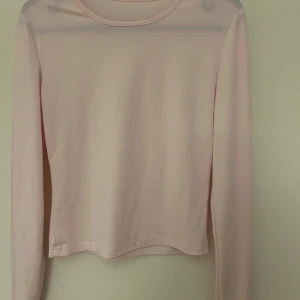 Ljusrosa långärmad tröja - Säljer en superfin ljusrosa långärmad tröja i mjukt material. Perfekt för både vår och höst. Den har en enkel och stilren design som passar till det mesta. Tröjan är i bra skick och redo för en ny ägare!