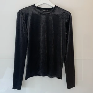 Svart sammetströja från BikBok - Säljer en elegant svart sammetströja från BikBok i storlek L. Tröjan har en mjuk och glansig yta som ger en lyxig känsla. Perfekt för höst och vinter, med långa ärmar och en normal passform. Passar både till vardags och festliga tillfällen. 🖤