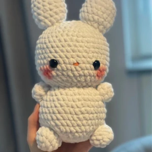 Vit virkad kanin - Säljer en supergullig vit virkad kanin med stora öron och små rosa kinder. Den är mjuk och perfekt som en kramgo kompis eller dekoration. Kaninen har svarta ögon och en liten orange nos. Perfekt present till någon som älskar söta och handgjorda saker! 🐰 Ca 26cm stor