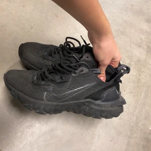 Svarta Nike sneakers - Säljer ett par svarta Nike sneakers i bra skick. De har en cool design med snörning och en robust sula som ger bra grepp. Perfekta för både träning och vardagsbruk. Skorna är bekväma och stilrena, vilket gör dem till ett måste i garderoben.